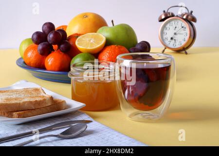 À 7 heures pour le petit déjeuner, le thé, le pain grillé avec du miel et des fruits. Banque D'Images