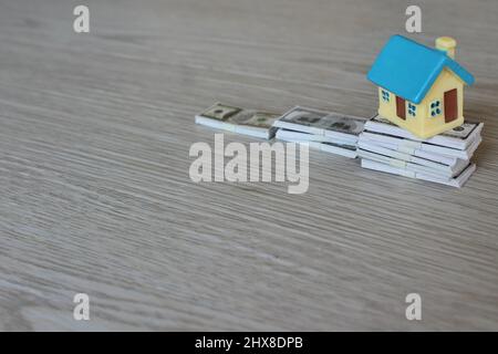Prix de l'immobilier en hausse, concept d'investissement immobilier. Maison de jouets sur la pile d'argent. Banque D'Images