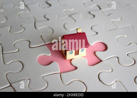 Concept de posséder une maison ou de terminer un achat de maison. Maison de jouets et pièces de puzzle manquantes. Banque D'Images