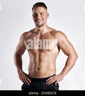 C'est le corps que le dévouement vous obtient. Photo d'un jeune homme musclé posant sur un fond blanc. Banque D'Images