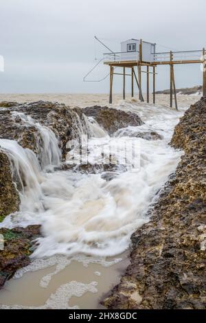 Vagues de l'océan se brisant sur des rochers de la côte atlantique française avec cabane de pêche près de la Rochelle, Charente Maritime, France Banque D'Images