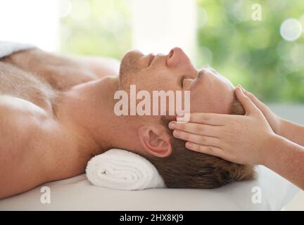 Laissez tomber votre stress Photo d'un beau homme qui se fait masser la tête au spa. Banque D'Images