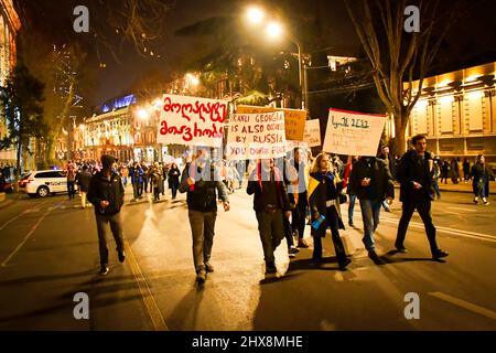 Tbilissi, Géorgie - 1st mars 2022 : un groupe de manifestants marche avec des affiches anti-russes contre Vladimir Poutine. Tenez-vous avec le mouvement de l'Ukraine. Banque D'Images