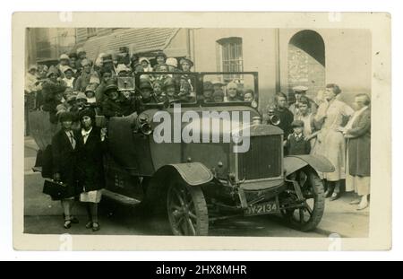 La carte postale originale des années 1920, carabanc, semble être une fête d'anniversaire pour enfants, ou une journée spéciale dehors, car certains portent des chapeaux de fête, de nombreux enfants entassés dans le carabanc, avec leurs parents, des spectateurs dans la rue. Brighton, Sussex, Angleterre, Royaume-Uni Banque D'Images