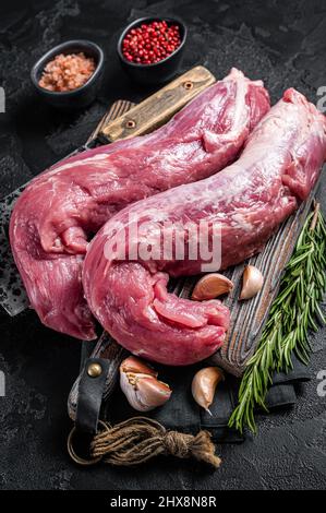 Filet de porc à la viande, filet cru non cuit sur le plateau de boucher avec un filet de viande.Arrière-plan noir.Vue de dessus Banque D'Images