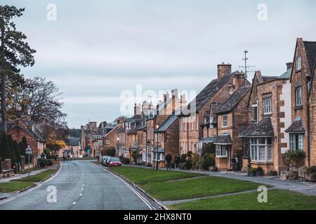 La pierre jaune Cotswold de ces pubs et maisons en fait une scène pittoresque. Banque D'Images