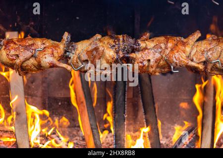 Rôtir du poulet sur un feu ouvert sur le marché. Banque D'Images