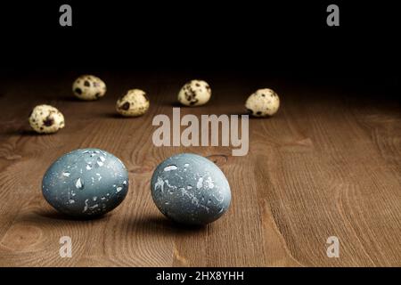 Peint le poulet et les œufs de caille sur une table en bois brun sur un fond sombre Banque D'Images