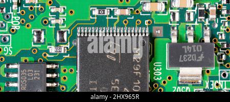 Gros plan d'une carte de circuit imprimé d'ordinateur, montrant différentes tailles de puces intégrées et d'autres composants électroniques. Banque D'Images
