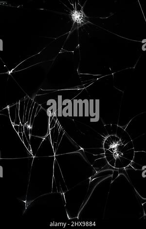 fissures sur fond de verre noir, casse abstraite de verre concept de destruction de trou. Banque D'Images