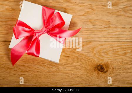 Boîte-cadeau avec ruban rouge sur fond de bois Banque D'Images