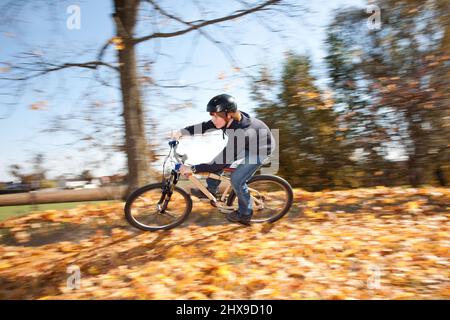 Boy saute avec sa moto hors route sur des rampes naturelles dans un espace ouvert et bénéficie d racing Banque D'Images