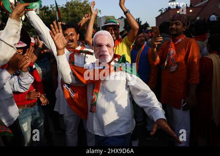 New Delhi, Inde. 10th mars 2022. Un partisan du parti au pouvoir en Inde, le Bharatiya Janata Party (BJP), portant un masque de danse du Premier ministre Narendra Modi, célèbre après avoir appris les résultats initiaux des élections de l'Assemblée de l'État de l'Uttar Pradesh. (Credit image: © Karma Sonam Bhutia/ZUMA Press Wire) Credit: ZUMA Press, Inc./Alamy Live News Banque D'Images