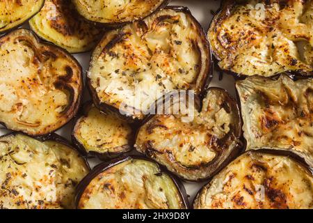 Vue panoramique sur les tranches d'aubergines rôties au four juteux, recouvertes d'un mélange d'ail haché, de basilic, de persil poivré et de sel. Reci maison et saine Banque D'Images