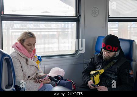Przemysl, Pologne. 10th mars 2022. Les gens sont vus en utilisant leur téléphone à l'intérieur du train sur le chemin de Lviv. Malgré des millions d'Ukrainiens fuyant à cause de l'invasion russe, des milliers d'autres ont décidé de retourner en Ukraine pour aider à lutter contre l'agression russe. (Credit image: © Hesther ng/SOPA Images via ZUMA Press Wire) Credit: ZUMA Press, Inc./Alamy Live News Banque D'Images