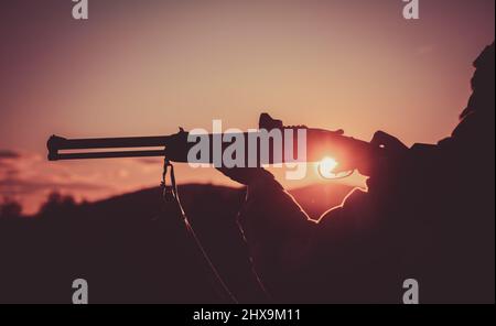 Calibres de fusils de chasse. Fusil Hunter silhoueté dans beau coucher de soleil. Silhouette du chasseur. Tirez la gâchette du fusil de chasse. Canon d'un canon Banque D'Images