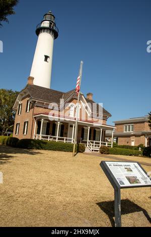 Île Saint-Simon, Géorgie - 21 février 2022 : Visiteur au sommet du phare de l'île Saint-Simons avec maison de gardien et panneau de visiteur. Banque D'Images