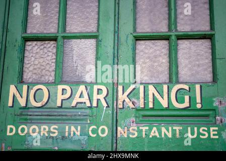 Portes de garage peintes à l'ancienne avec lettrage de style vintage ne demandant pas de stationnement, portes en utilisation constante. Porte d'accès au garage pour les affaires Banque D'Images
