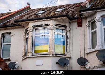 Drapeau de l'Ukraine suspendu dans la fenêtre d'une ancienne maison à Southend sur la mer, Essex, Royaume-Uni, en soutien du pays pendant la guerre avec la Russie Banque D'Images