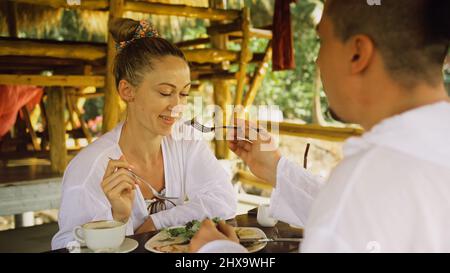 Un jeune homme et une femme séduisants mangent et boivent des boissons savoureuses en passant du temps dans un café flottant local traditionnel sur l'eau.J'aime un couple heureux qui a du bre Banque D'Images
