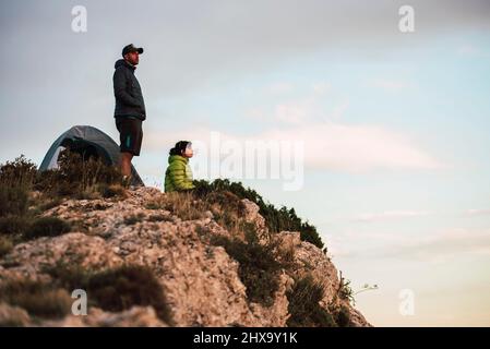 Femme et homme assis sur la falaise et surplombant le paysage. Banque D'Images