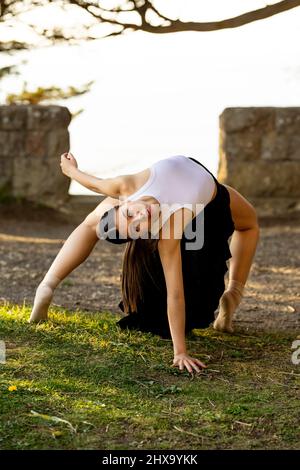 Teenage Female Dance faisant le backbend dans le parc Banque D'Images