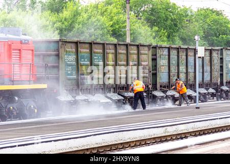 Kemerovo (Russie), le 03 juin 2021. Le personnel d'entretien de la gare ferroviaire effectue les réparations actuelles du ballast de la voie ferrée en versant de gros g. Banque D'Images