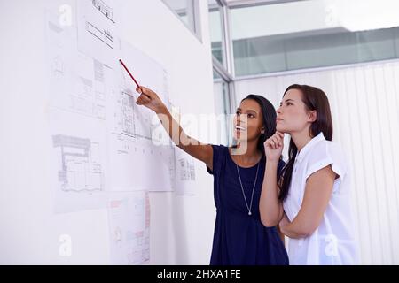 Experts au travail. Photo de deux architectes féminins examinant les plans de construction. Banque D'Images