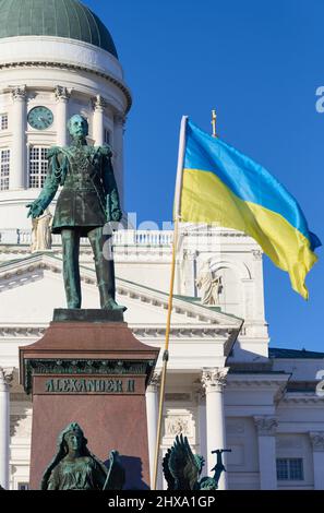 Helsinki, Finlande - 26 février 2022 : statue de l'ancien tsar russe Alexander II et drapeau ukrainien dans un rassemblement contre l'occupant militaire russe Banque D'Images