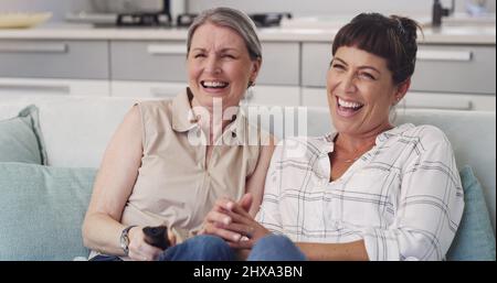 Ce film est hilarant maman. Prise de vue de la mère et de la fille en regardant une émission de télévision ensemble. Banque D'Images