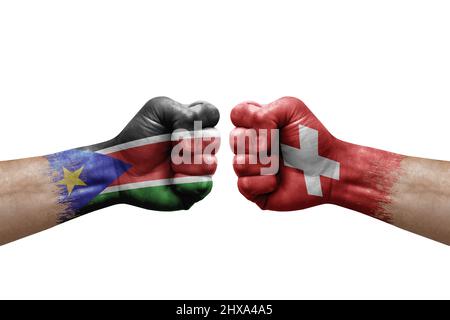 Deux mains poinçonner l'une à l'autre sur fond blanc. Drapeaux de pays peint les poings, le concept de crise de conflit entre le sud du soudan et la suisse Banque D'Images