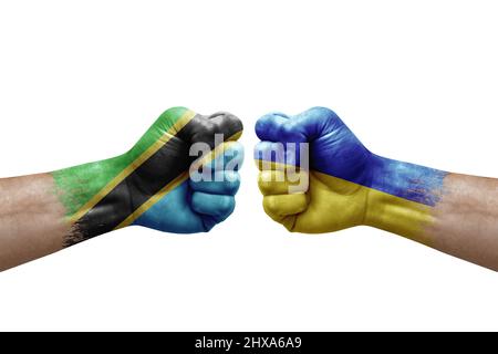 Deux mains poinçonner l'une à l'autre sur fond blanc. Les drapeaux de pays ont peint les poings, le concept de crise de conflit entre la tanzanie et l'ukraine Banque D'Images