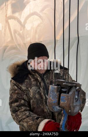 Le déflecteur à neige met une élingue en ruban adhésif sur le crochet d'une grue de camion Banque D'Images