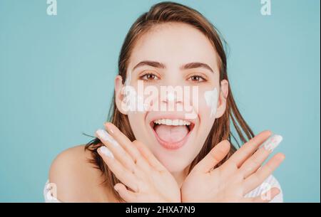 Drôle belle jeune femme avec la peau propre et fraîche application de crème pour le visage. Banque D'Images