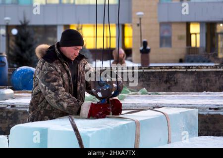 Le déflecteur à neige met une élingue en ruban adhésif sur le crochet d'une grue de camion Banque D'Images