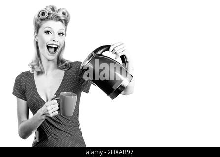 Drôle blonde pinup femme faisant le thé. Modèle femme remplissant le mug avec de l'eau chaude, espace de copie vide. Banque D'Images