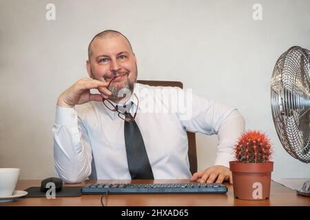 L'homme décrit comiquement le travail d'un homme d'affaires. Il montre le contentement et la joie sur son visage et sa posture. Banque D'Images