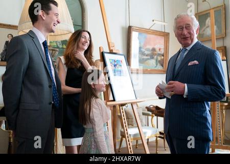 Le Prince de Galles rencontre Isabella Grover, âgée de 7 ans, gagnante nationale du concours de création de timbres « héros de la pandémie » de Royal Mail, tout en regardant les créations gagnantes à Clarence House à Londres. Date de la photo: Jeudi 10 mars 2022. Banque D'Images