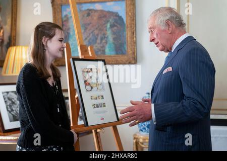 Le Prince de Galles rencontre Jessica Roberts, âgée de 15 ans, gagnante nationale du concours de création de timbres « Heroes of the Pandemic » de Royal Mail, tout en regardant les créations gagnantes à Clarence House à Londres. Date de la photo: Jeudi 10 mars 2022. Banque D'Images