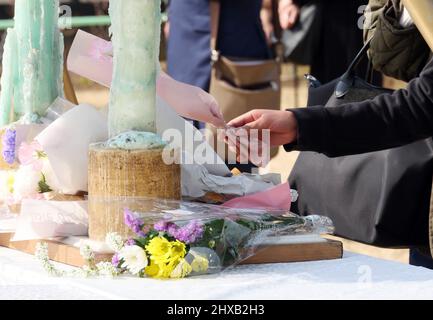 Tokyo, Japon. 11th mars 2022. Une femme dépose un bouquet de fleurs et prie pour les victimes du tremblement de terre et du tsunami de 3,11 à Tokyo le vendredi 11 mars 2022. Le Japon a marqué le 11th anniversaire du grand tremblement de terre de l'est du Japon qui a tué quelque 20 000 personnes en 2011. Credit: Yoshio Tsunoda/AFLO/Alay Live News Banque D'Images