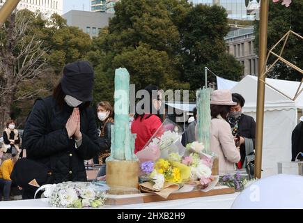 Tokyo, Japon. 11th mars 2022. Une femme dépose un bouquet de fleurs et prie pour les victimes du tremblement de terre et du tsunami de 3,11 à Tokyo le vendredi 11 mars 2022. Le Japon a marqué le 11th anniversaire du grand tremblement de terre de l'est du Japon qui a tué quelque 20 000 personnes en 2011. Credit: Yoshio Tsunoda/AFLO/Alay Live News Banque D'Images