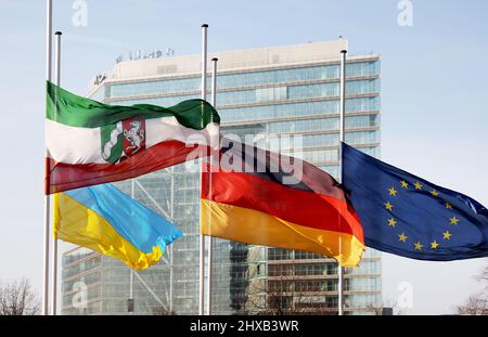 Düsseldorf, Allemagne. 11th mars 2022. Les drapeaux de la Rhénanie-du-Nord-Westphalie, de l'Ukraine, de l'Allemagne et de l'Europe sont en Berne devant la porte de la ville comme drapeau de deuil pour la nouvelle Journée du souvenir des victimes du terrorisme. Le 11 mars est devenu une journée officielle de commémoration en Allemagne cette année. Cette date est liée à la Journée européenne du souvenir des victimes du terrorisme, qui a été instituée après les attentats à la bombe à caractère islamiste à Madrid le 11 mars 2004 crédit : Oliver Berg/dpa/Alamy Live News Banque D'Images