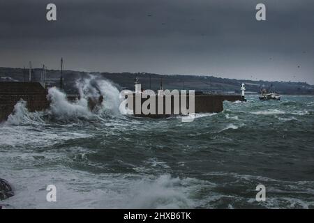 Un chalutier à faisceau de la flotte de pêche de Newlyn bascule fortement dans les mers accidentées comme elle met dans le port de Penzance pour des réparations. Banque D'Images