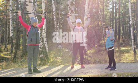 Femme de marche nordique dans la nature. Les filles et les enfants utilisent des bâtons de randonnée et des bâtons nordiques, des sacs à dos. La famille voyage et se rend pour le sport. Enfant est l Banque D'Images