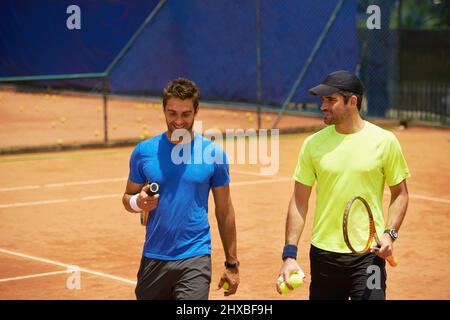Leurs amis et leurs grands rivaux sur le terrain. Deux joueurs de tennis masculins sur le court. Banque D'Images