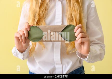 Femme avec bloc menstruel réutilisable sur fond jaune Banque D'Images