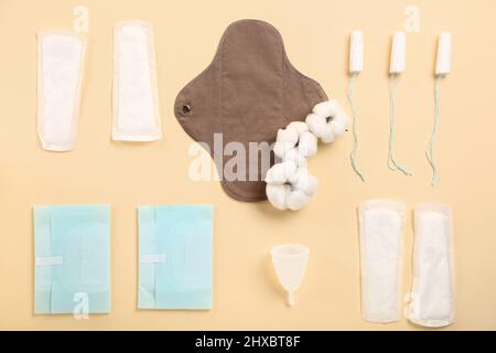 Différents tampons, tasses et tampons menstruels sur fond jaune Banque D'Images