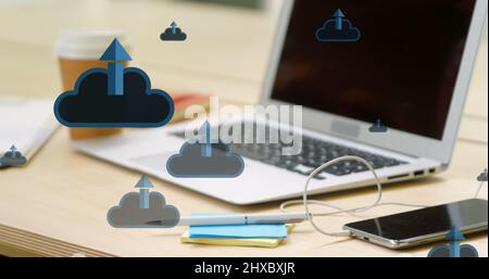 Image des icônes de nuages et de flèches sur le smartphone et l'ordinateur portable sur le bureau Banque D'Images