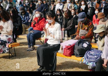 Tokyo, mars 11. 11th mars 2011. Les gens observent un moment de silence à 2 h 46, heure locale, dans le parc Hibiya à Tokyo, au Japon, le 11 mars 2022, pour commémorer les victimes d'un séisme de magnitude 9,0 et d'un tsunami qui a frappé le nord-est du Japon le 11 mars 2011. Credit: Zhang Xiaoyu/Xinhua/Alay Live News Banque D'Images