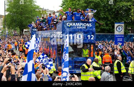 Les joueurs et le personnel du Chelsea FC défilent sur un bus à toit ouvert passant devant Stamford Bridge avec la coupe d'Europe et la coupe FA gagnée en 2011-2012. Banque D'Images